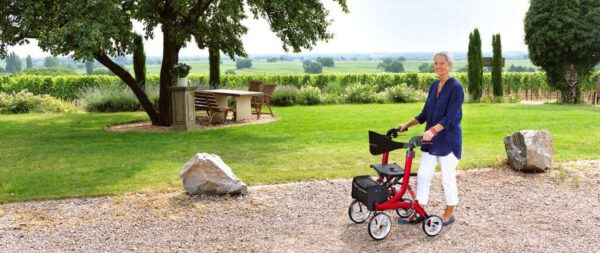 Frau mit bescomedical Rollator läuft draußen auf einem Weg